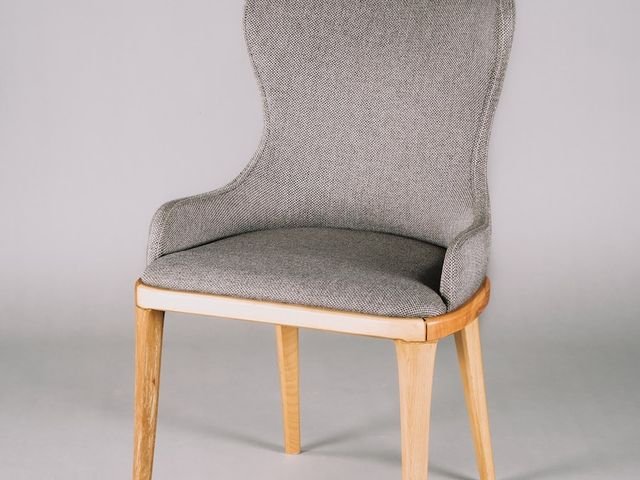 Grey upholstered dining chair with wooden legs