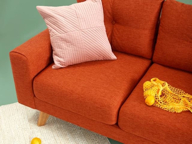 Rust coloured fabric sofa with cushion
